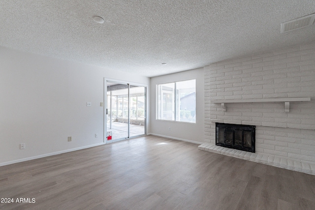 unfurnished living room featuring a textured ceiling, a fireplace, and hardwood / wood-style floors