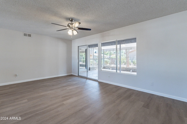 empty room featuring a textured ceiling, dark wood-type flooring, and ceiling fan