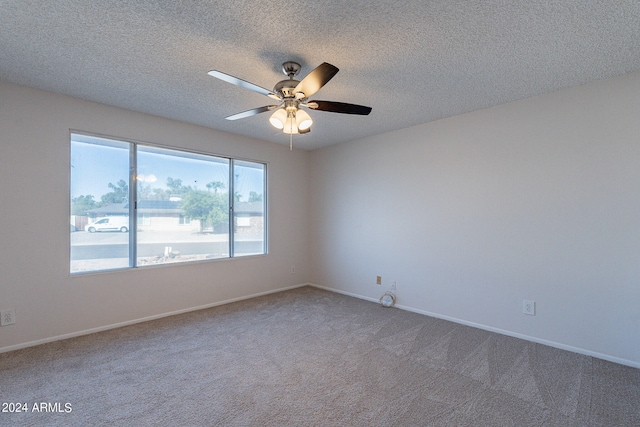 spare room featuring ceiling fan, carpet flooring, and a textured ceiling