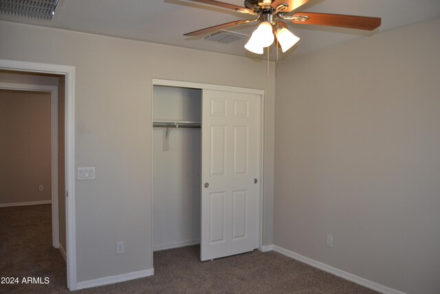 unfurnished bedroom with ceiling fan, carpet flooring, and a closet