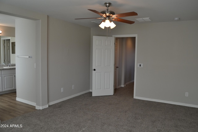 carpeted empty room featuring sink and ceiling fan