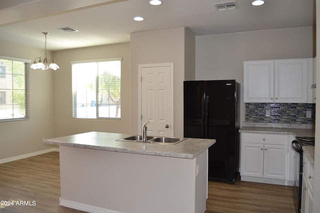 kitchen with black appliances, a wealth of natural light, wood-type flooring, and decorative backsplash