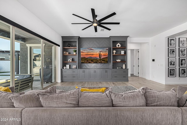 living room with ceiling fan, light hardwood / wood-style floors, and built in shelves