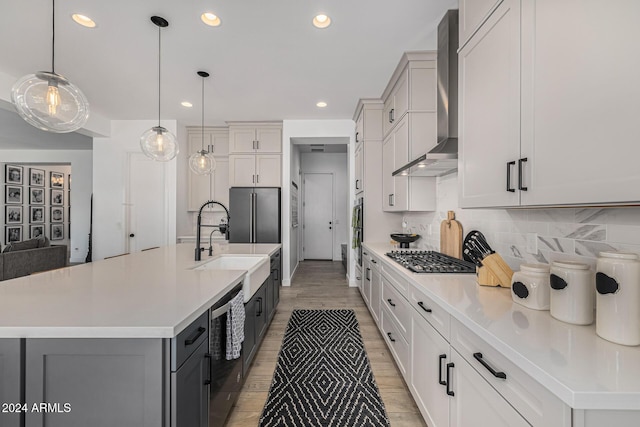 kitchen with tasteful backsplash, a spacious island, pendant lighting, and wall chimney range hood