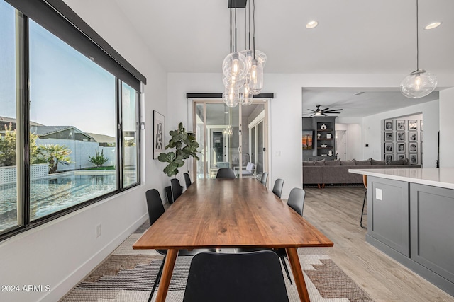 dining space with ceiling fan and light wood-type flooring