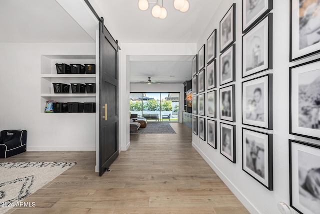 hallway featuring a barn door and light hardwood / wood-style floors