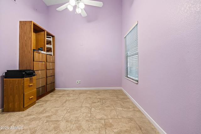 tiled spare room with ceiling fan