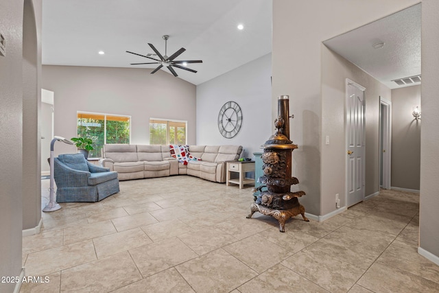 tiled living room with ceiling fan and high vaulted ceiling