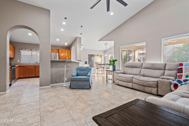 living room with ceiling fan, plenty of natural light, and high vaulted ceiling