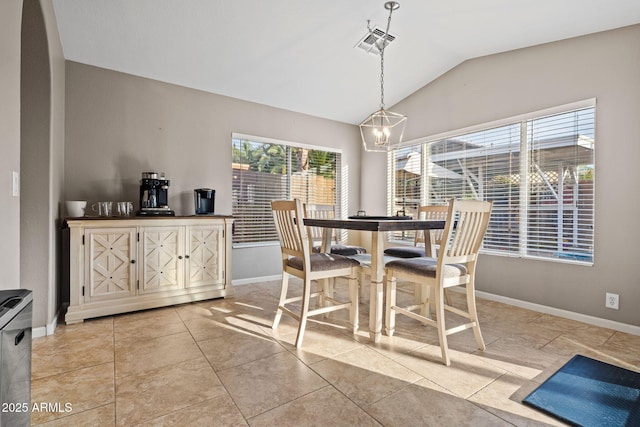 dining space featuring lofted ceiling, light tile patterned flooring, and an inviting chandelier