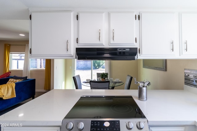 kitchen with white cabinets, black range oven, and extractor fan