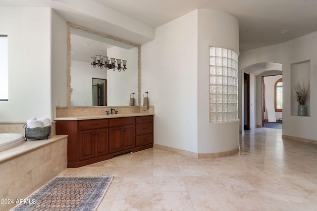 bathroom with vanity, tiled bath, tile patterned floors, and a chandelier