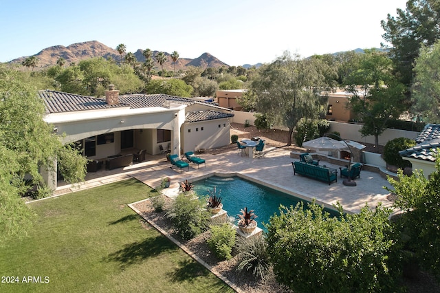 view of swimming pool with a mountain view, a patio area, and a lawn