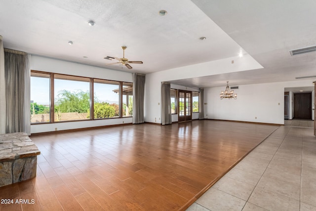 living room with a textured ceiling, ceiling fan with notable chandelier, and light hardwood / wood-style flooring