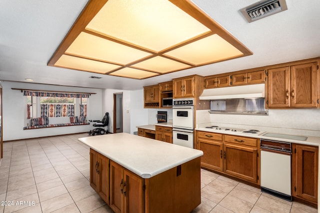 kitchen with light tile patterned flooring, white appliances, and a center island