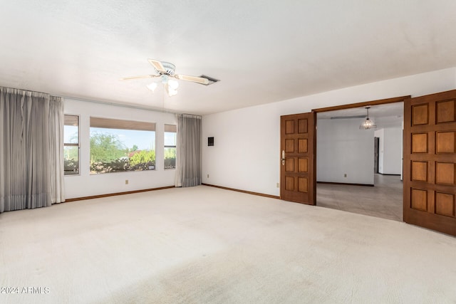 spare room with ceiling fan with notable chandelier and light carpet