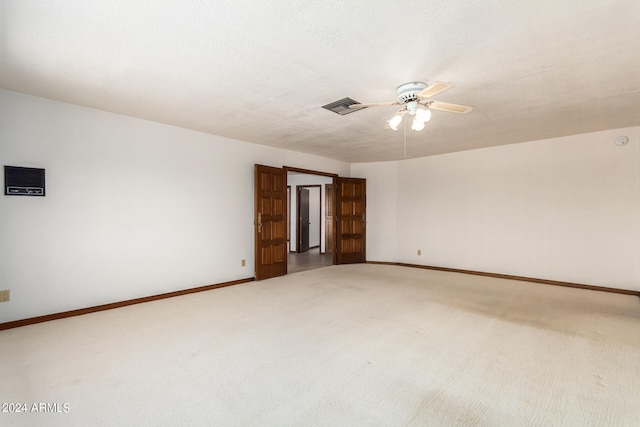 spare room featuring ceiling fan, a textured ceiling, and carpet