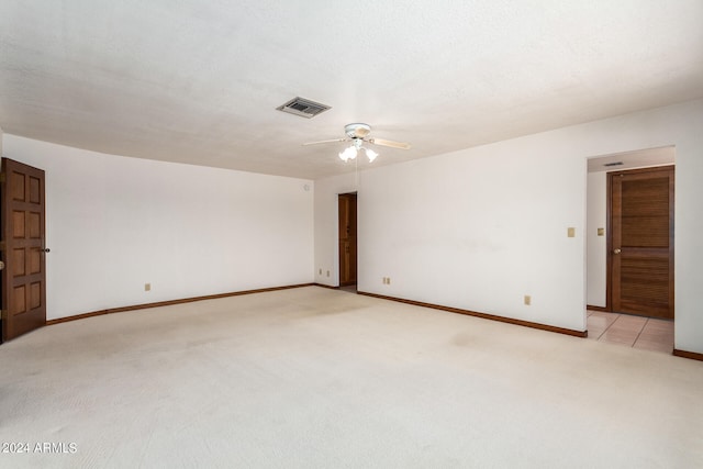 empty room featuring light carpet, ceiling fan, and a textured ceiling