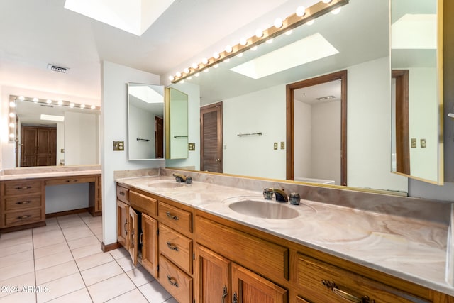 bathroom featuring vanity, a skylight, and tile patterned floors