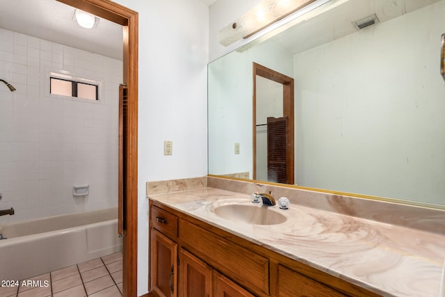 bathroom with tiled shower / bath, vanity, and tile patterned flooring