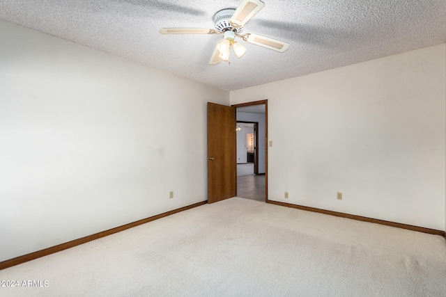 spare room featuring a textured ceiling, carpet, and ceiling fan