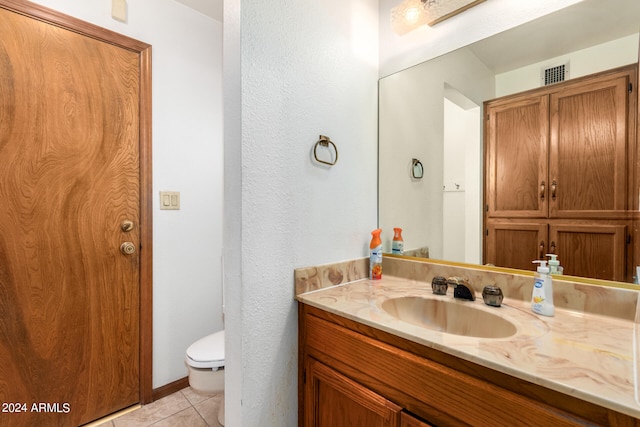 bathroom with vanity, toilet, and tile patterned floors