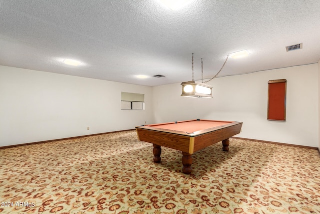 recreation room with pool table, a textured ceiling, and light colored carpet