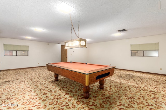 recreation room featuring pool table, a textured ceiling, and light colored carpet