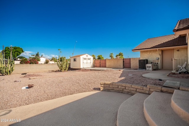 view of patio / terrace featuring central AC unit and a shed