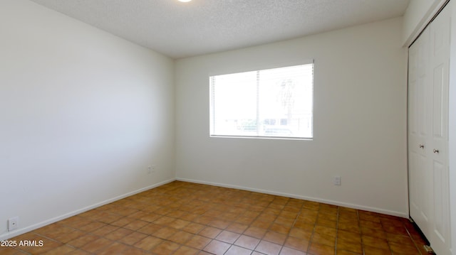 3556 W Augusta Ave, Phoenix, AZ 85051 - unfurnished bedroom with a closet, a textured ceiling, tile patterned flooring, and baseboards