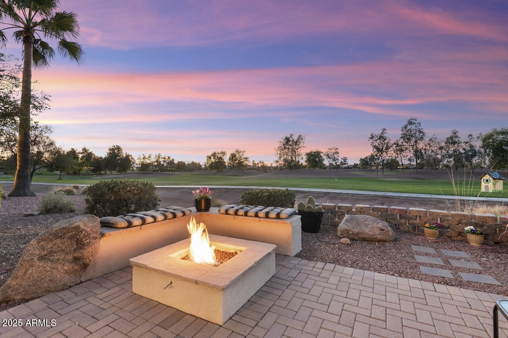 patio terrace at dusk featuring an outdoor fire pit