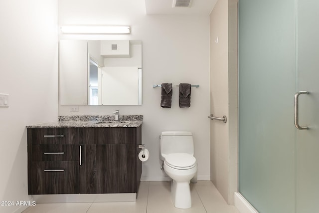 bathroom featuring tile patterned flooring, vanity, toilet, and walk in shower