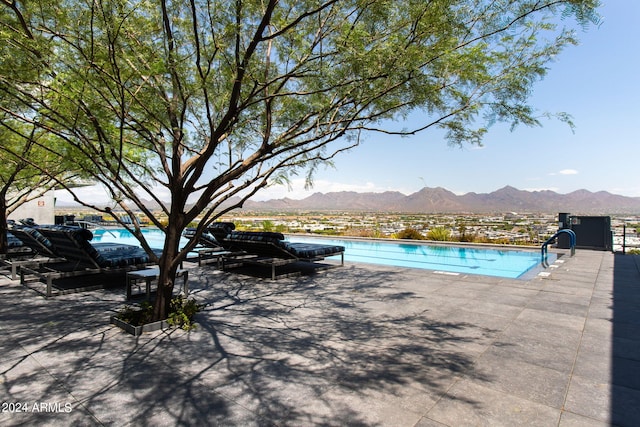 view of swimming pool featuring a mountain view and a patio