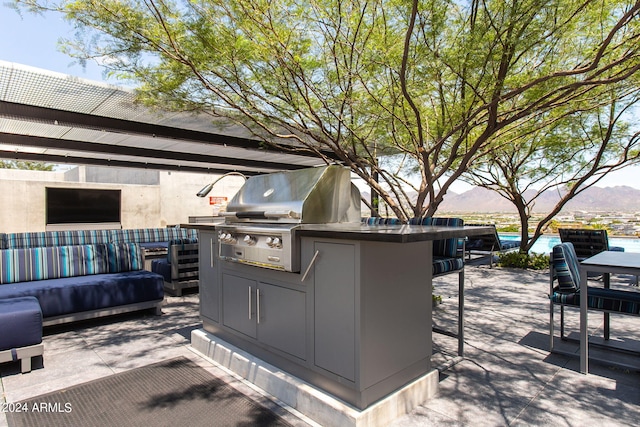 view of patio with a mountain view, a grill, and exterior kitchen