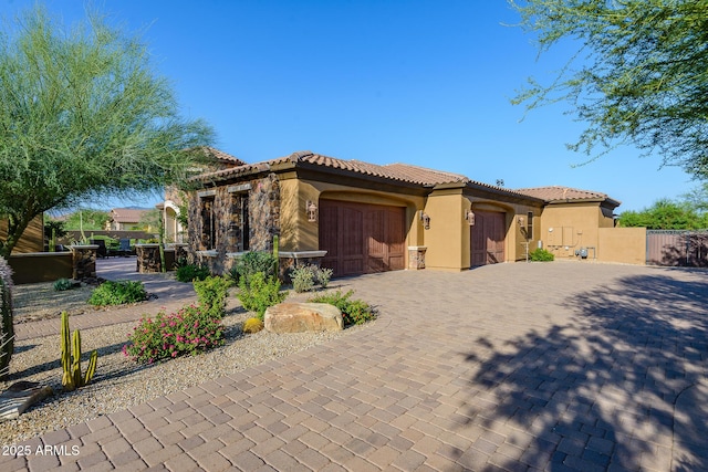 35443 N 87th Pl, Scottsdale, AZ 85266 - mediterranean / spanish-style home with an attached garage, stucco siding, a tile roof, decorative driveway, and a gate