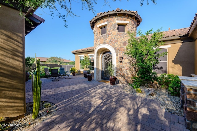 35443 N 87th Pl, Scottsdale, AZ 85266 - view of front facade featuring a patio area, stone siding, stucco siding, a tiled roof, and outdoor dining space