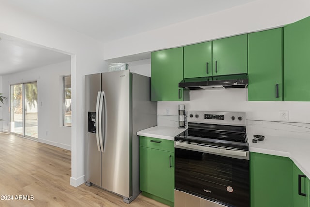 kitchen with green cabinets, stainless steel appliances, and light wood-type flooring