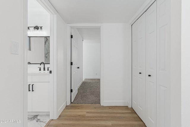 corridor featuring light hardwood / wood-style flooring and sink