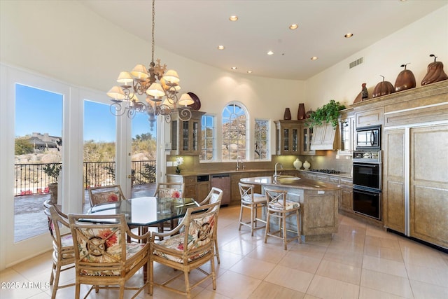 tiled dining area with sink, a wealth of natural light, and an inviting chandelier