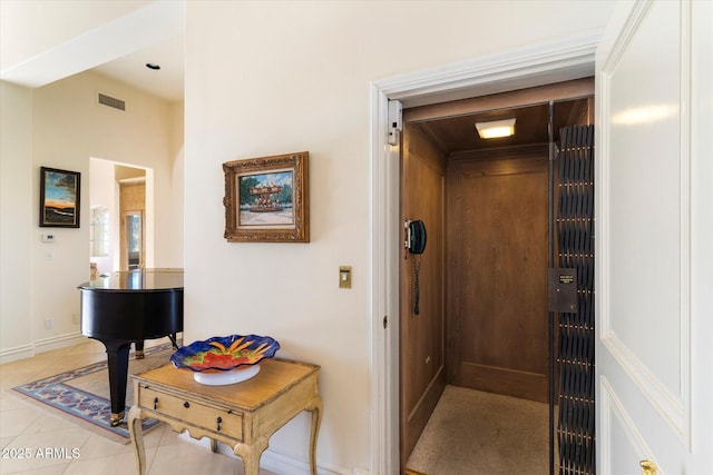 hall with light tile patterned floors and elevator