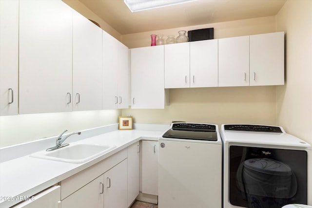 laundry area with cabinets, washer and dryer, and sink