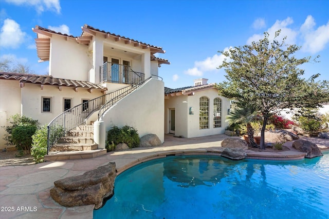 rear view of property with a balcony and a patio