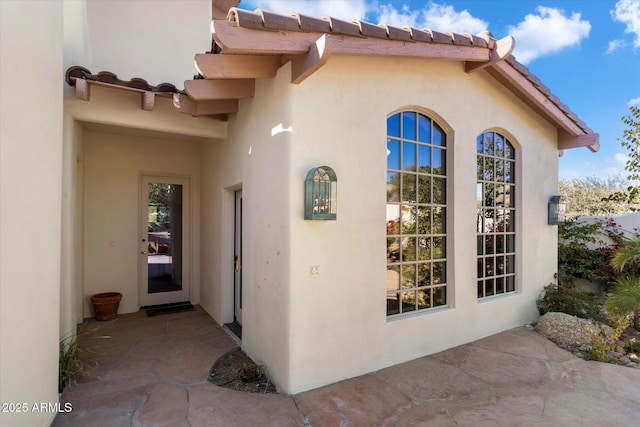 view of exterior entry featuring a patio area