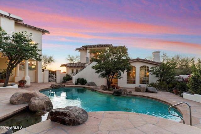 pool at dusk with a patio