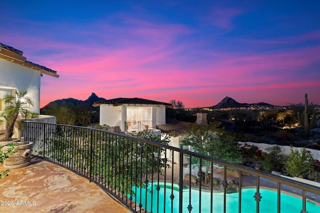 balcony at dusk featuring a mountain view