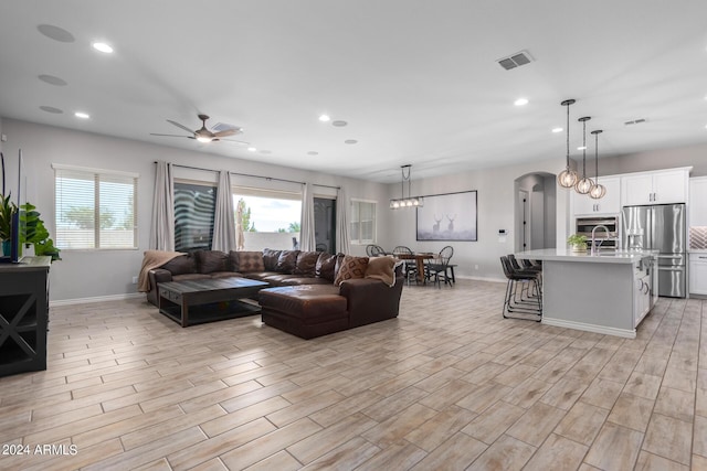 living room with ceiling fan, plenty of natural light, and sink