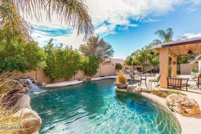 view of pool with a patio, pool water feature, and ceiling fan