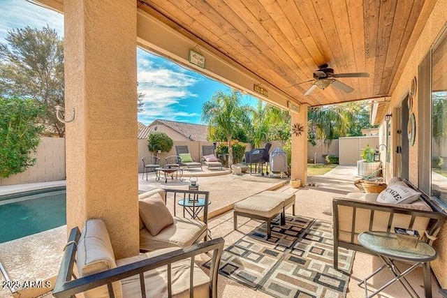 view of patio featuring a fenced in pool and ceiling fan