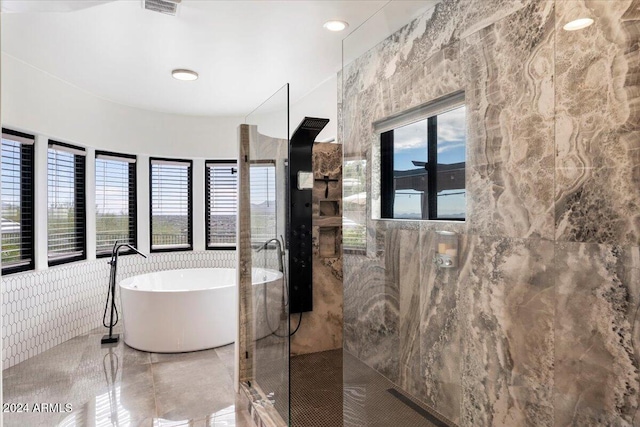 bathroom with tile walls and separate shower and tub