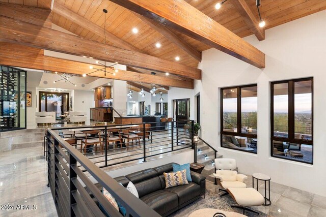 living room featuring beam ceiling, wood ceiling, an inviting chandelier, and high vaulted ceiling